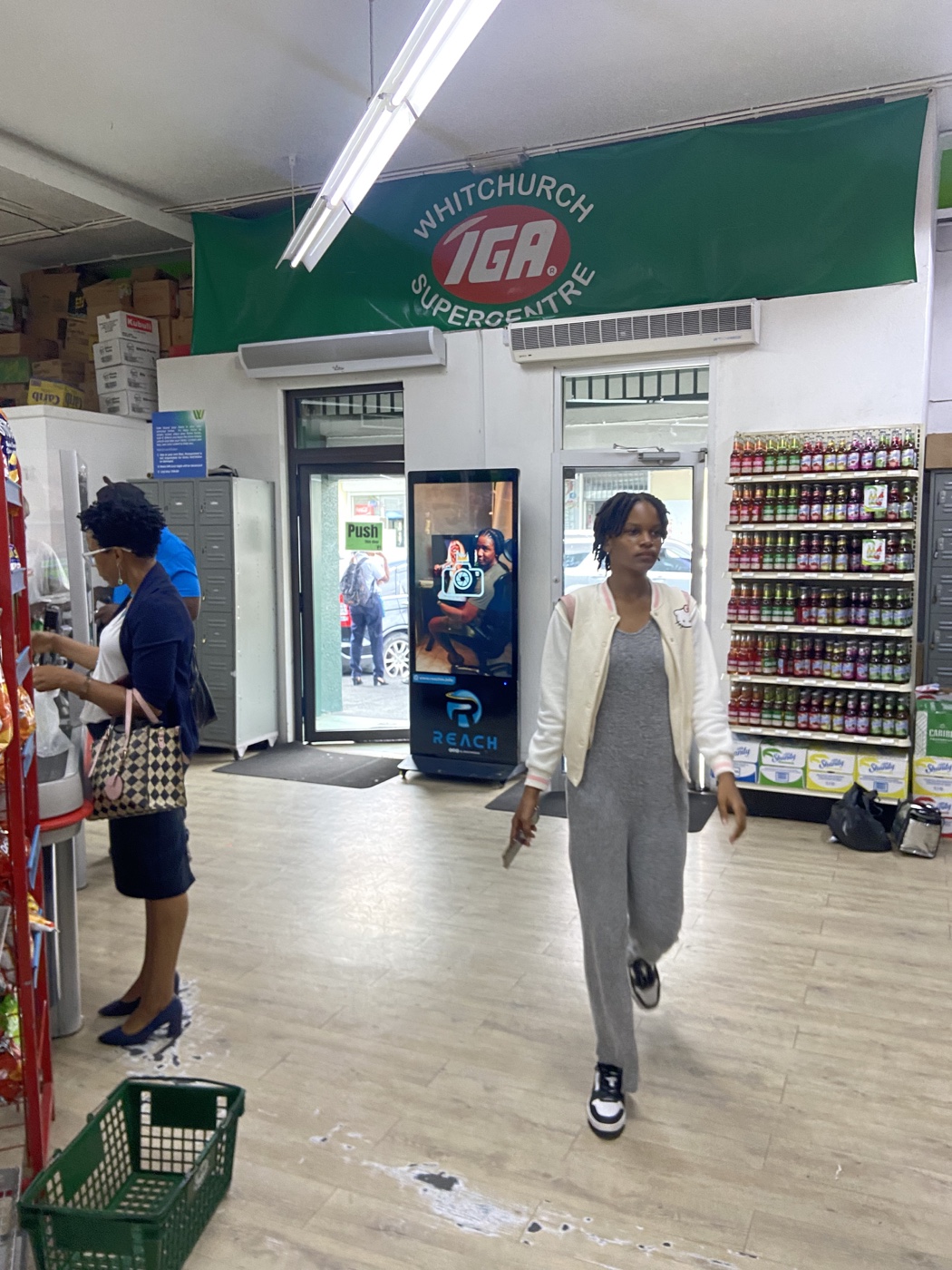 Reach Media screen visible from the Witchurch IGA supermarket floor